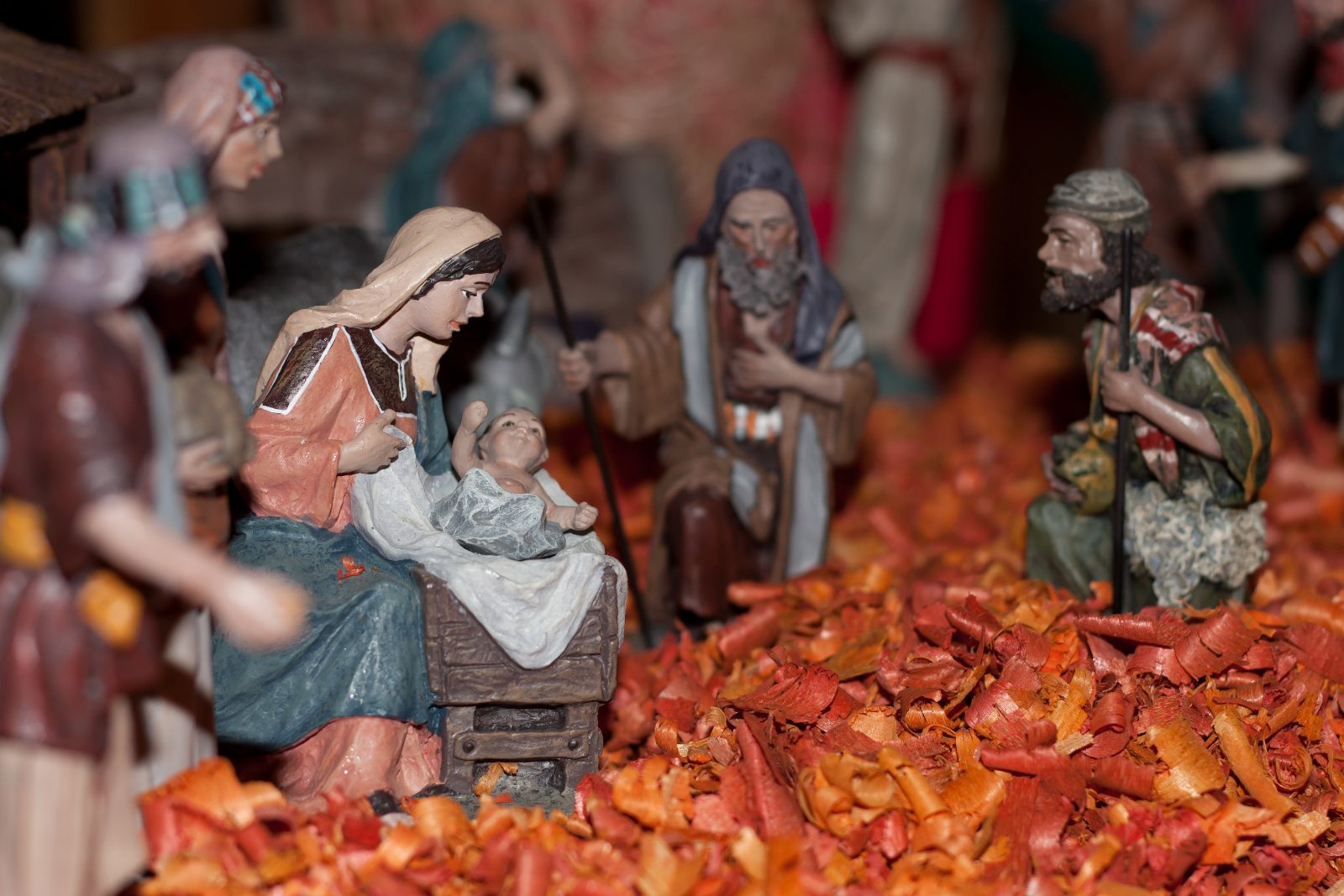 Santons de bergers agenouillés devant la mangeoire dans une crèche de Noël provençale